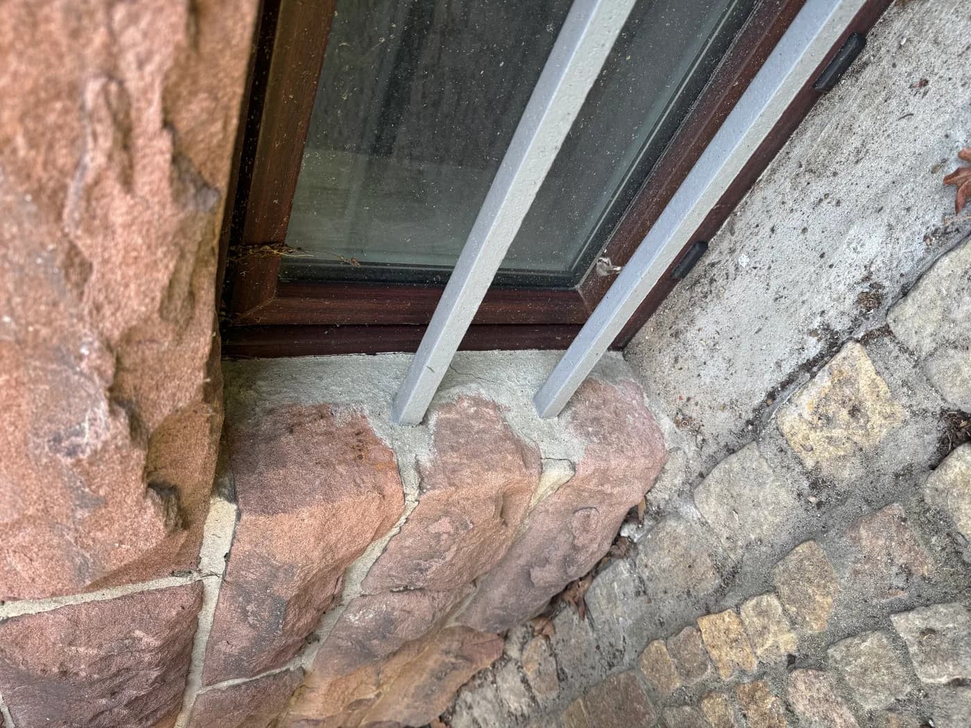 Detailaufnahme eines Kellerfensters und des angrenzenden Mauerwerks